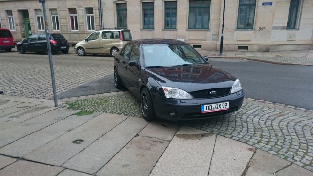 Auto um 90° gedreht auf Grenze einer Schrägparklücke